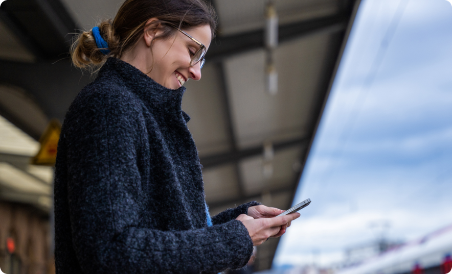 Woman at Train Station with FAIRTIQ App